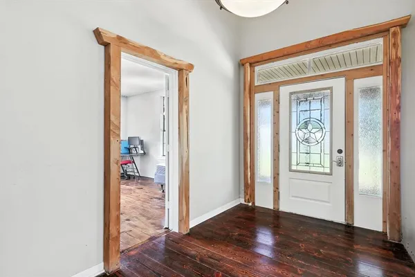 a view of a hallway with wooden floor and a living room