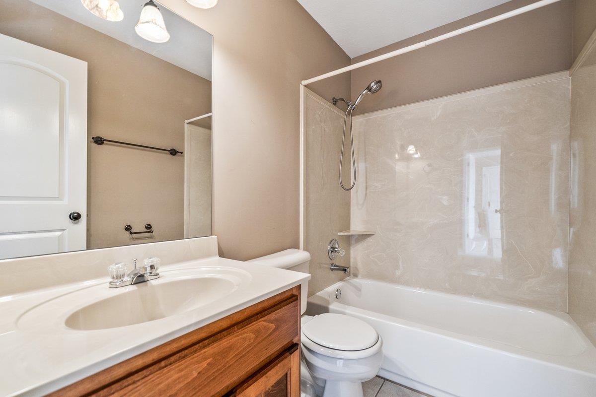 583 Rosemark Road Atoka, TN 38004 - Photo 21 of 25 a bathroom with a granite countertop sink toilet mirror and bathtub