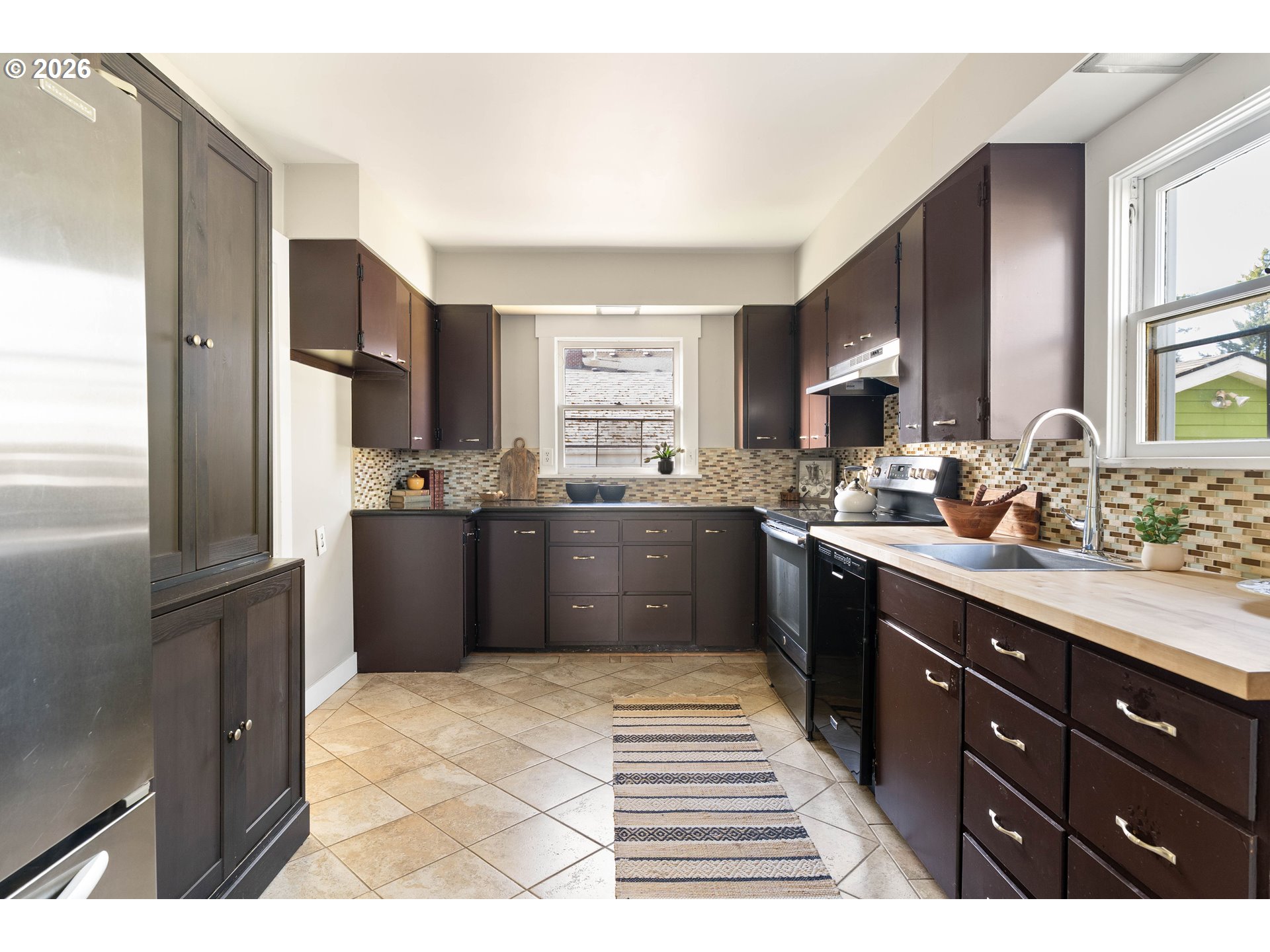 3215 Northeast 63rd Avenue Portland, OR 97213 - Photo 12 of 47 a kitchen with stainless steel appliances kitchen island granite countertop a refrigerator and a sink