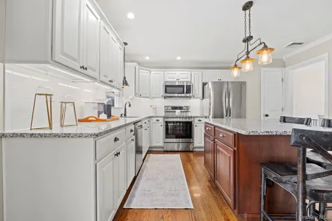 a kitchen with stainless steel appliances granite countertop a sink and a refrigerator