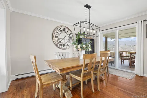 a view of a dining room and livingroom with furniture wooden floor a chandelier