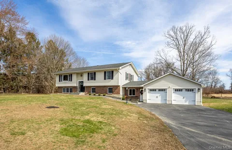 a front view of a house with a yard and trees