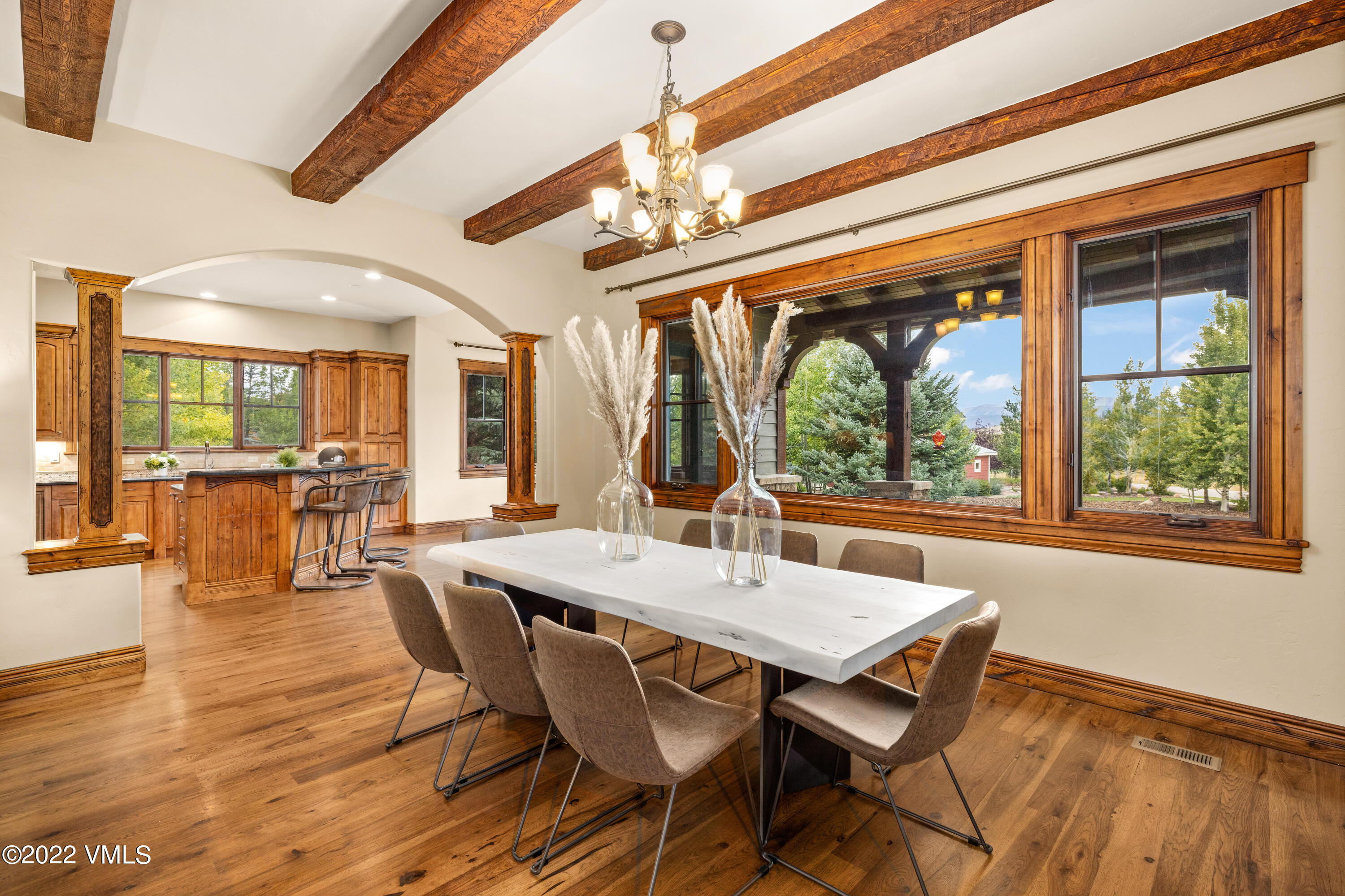 2376 Eagle Ranch Road Eagle, CO 81631 - Photo 8 of 52 a dining room with wooden floor a chandelier a wooden table and chairs