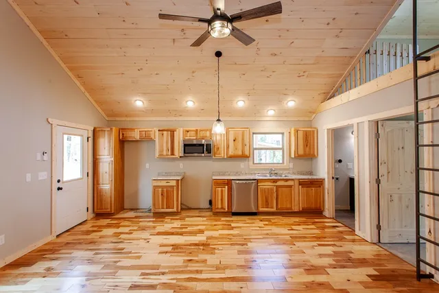 a kitchen with granite countertop stainless steel appliances a sink window and cabinets