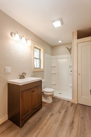 a utility room with wooden floor washer and dryer