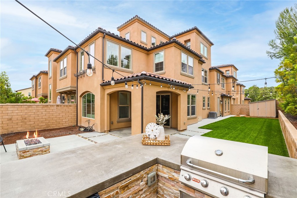 a view of a white house with large windows and a table and chairs under an umbrella