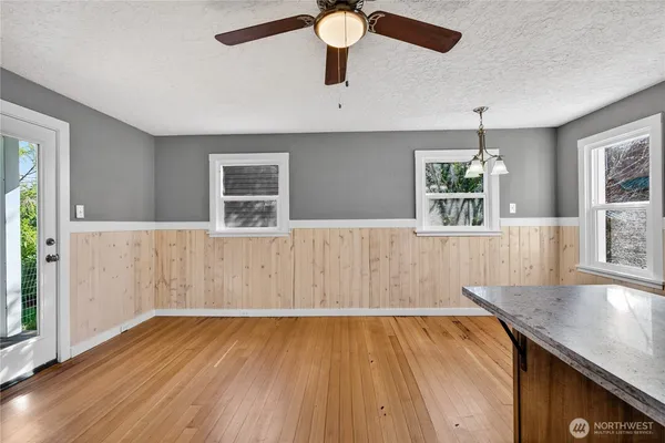 an empty room with wooden floor and windows