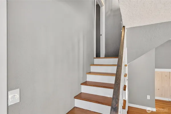 a view of staircase with wooden floor and white walls