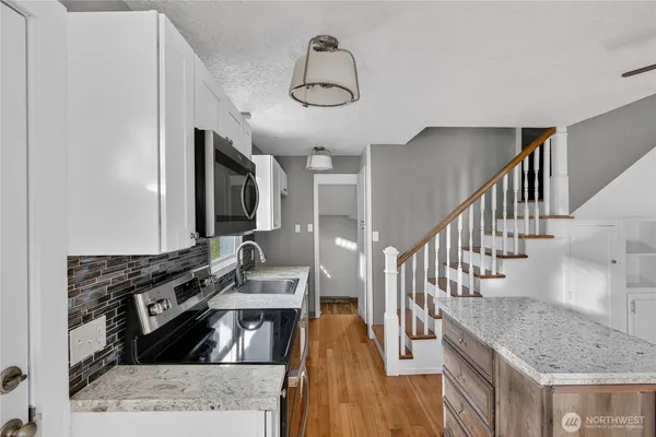 a kitchen with stainless steel appliances granite countertop a stove and a sink
