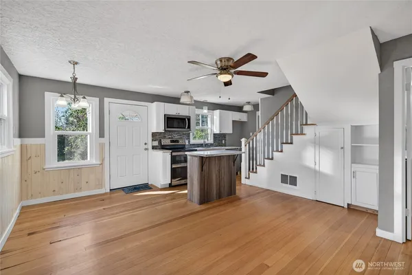 a view of kitchen with sink microwave and stove top oven