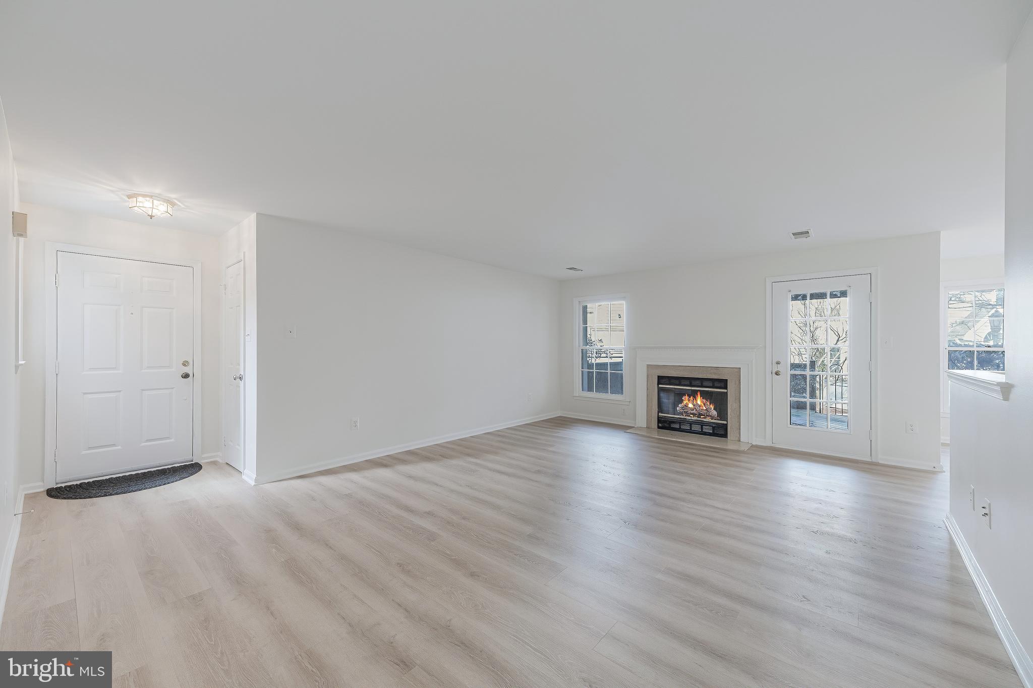 1427 Church Hill Place Reston, VA 20194 - Photo 3 of 30 an empty room with wooden floor fireplace and windows