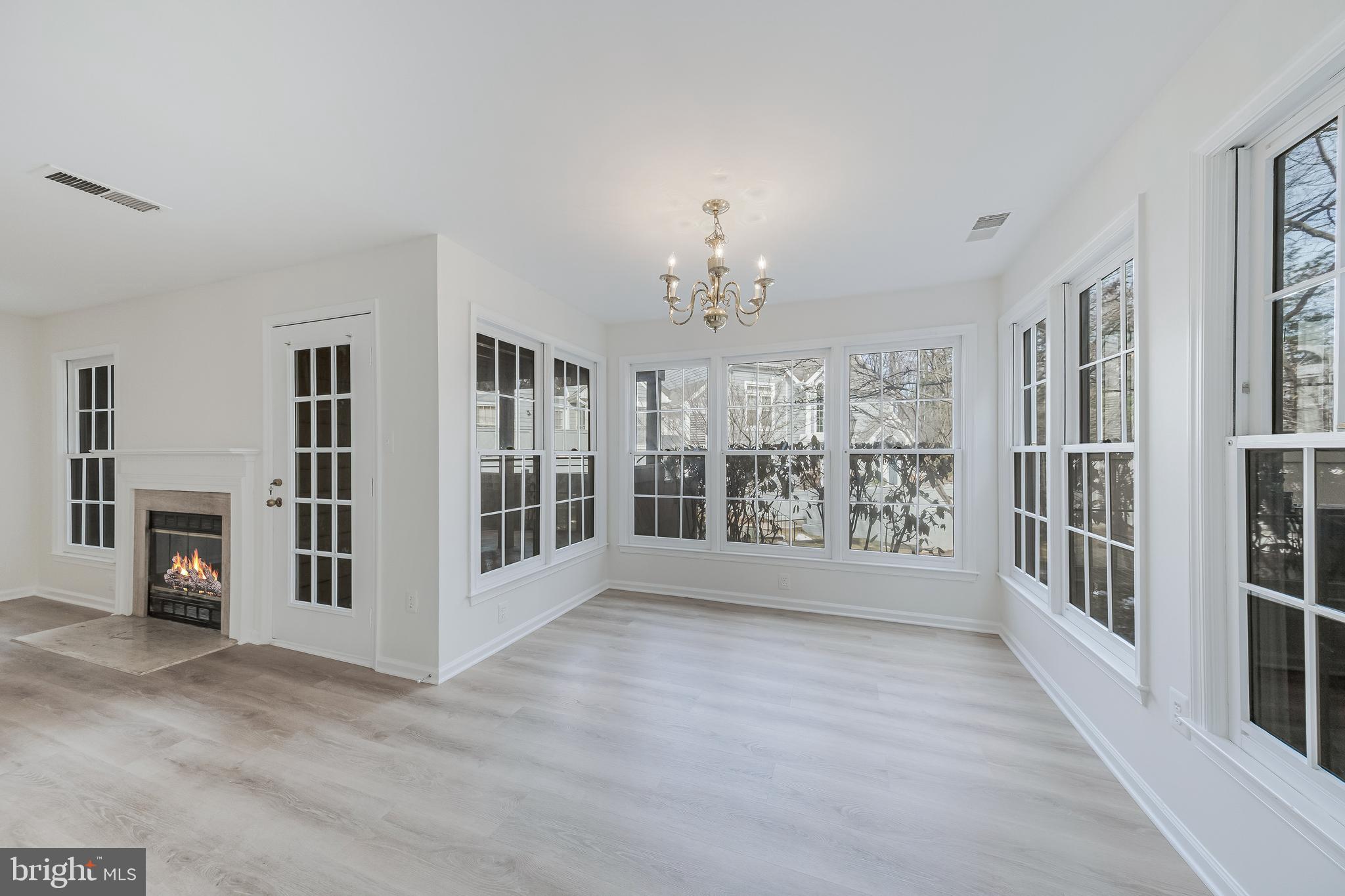1427 Church Hill Place Reston, VA 20194 - Photo 8 of 30 a view of an empty room with a fireplace and large windows
