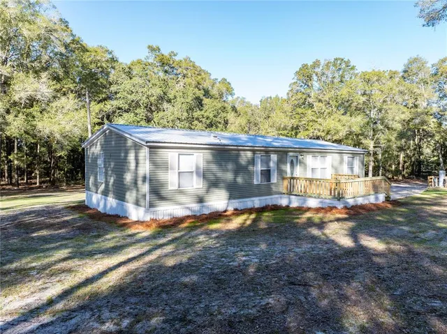 a view of a house with backyard and a tree