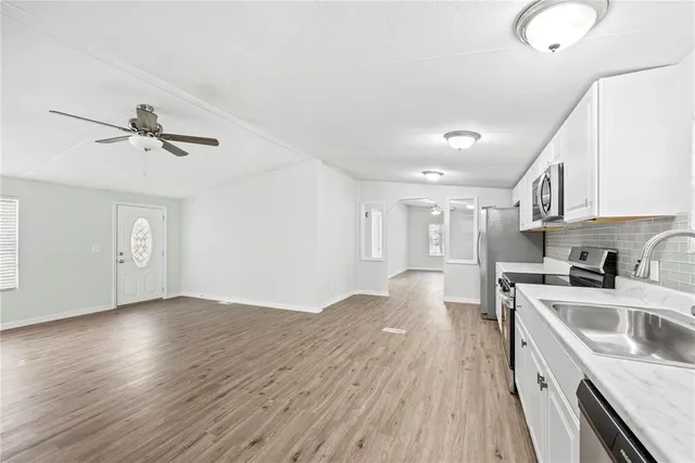 a view of a kitchen with sink and wooden floor