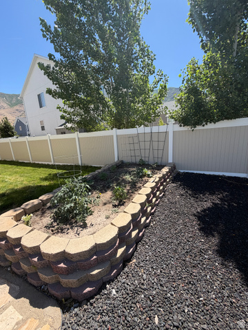 118 Tram Rock Rd. Lake Point, UT 84074 - Photo 32 of 34 Landscaped garden bed, planted greens, and a trellis