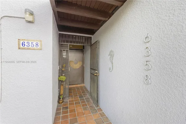 a hallway with a couch and a potted plant