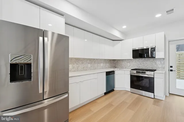 a kitchen with stainless steel appliances granite countertop a refrigerator stove and microwave