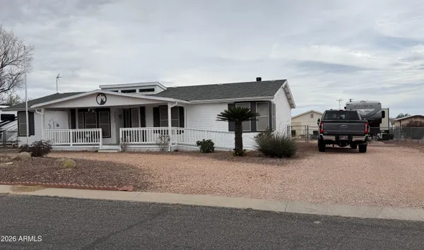 a front view of a house with cars parked in front of it