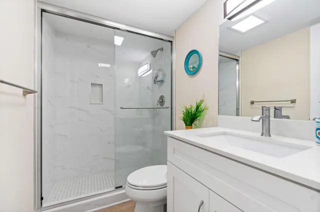 a bathroom with a sink a toilet and shower