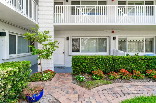 a front view of a house with a yard and potted plants