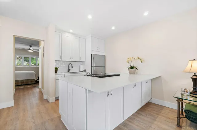 a kitchen with white cabinets and sink