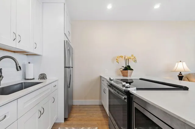a kitchen with stainless steel appliances a sink a stove and a refrigerator