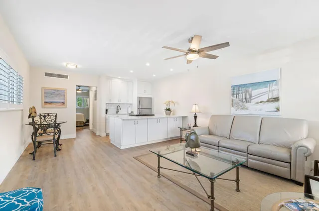 a living room with furniture kitchen view and a dining table