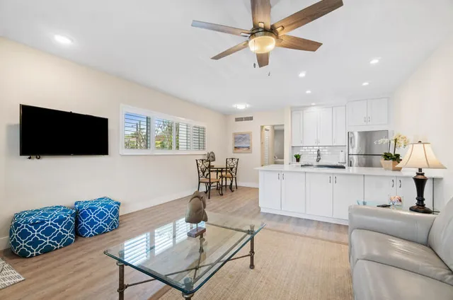 a living room with furniture kitchen view and a flat screen tv