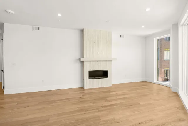 a living room with furniture a flat screen tv and kitchen view