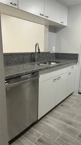 a kitchen with granite countertop a sink and cabinets