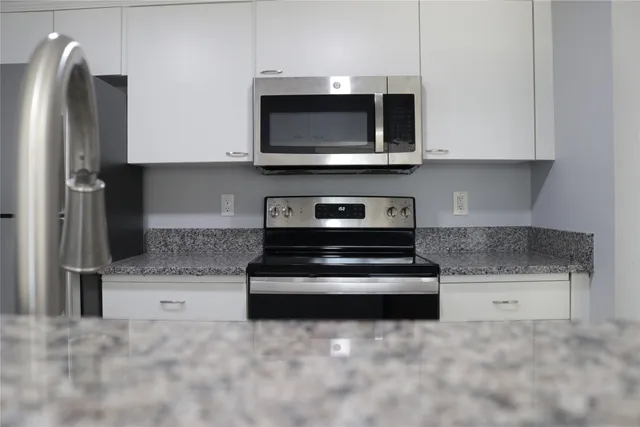 a kitchen with stainless steel appliances granite countertop a refrigerator and a stove top oven