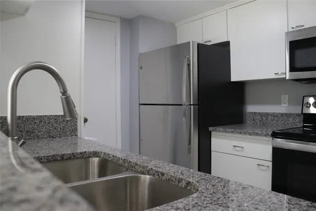 a kitchen with a refrigerator sink and cabinets