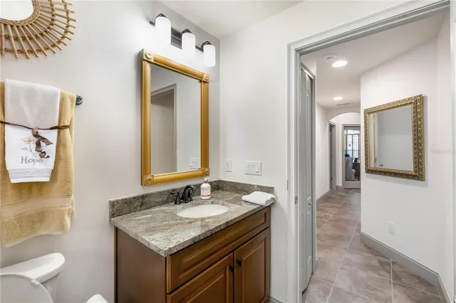 a bathroom with a granite countertop sink and a mirror