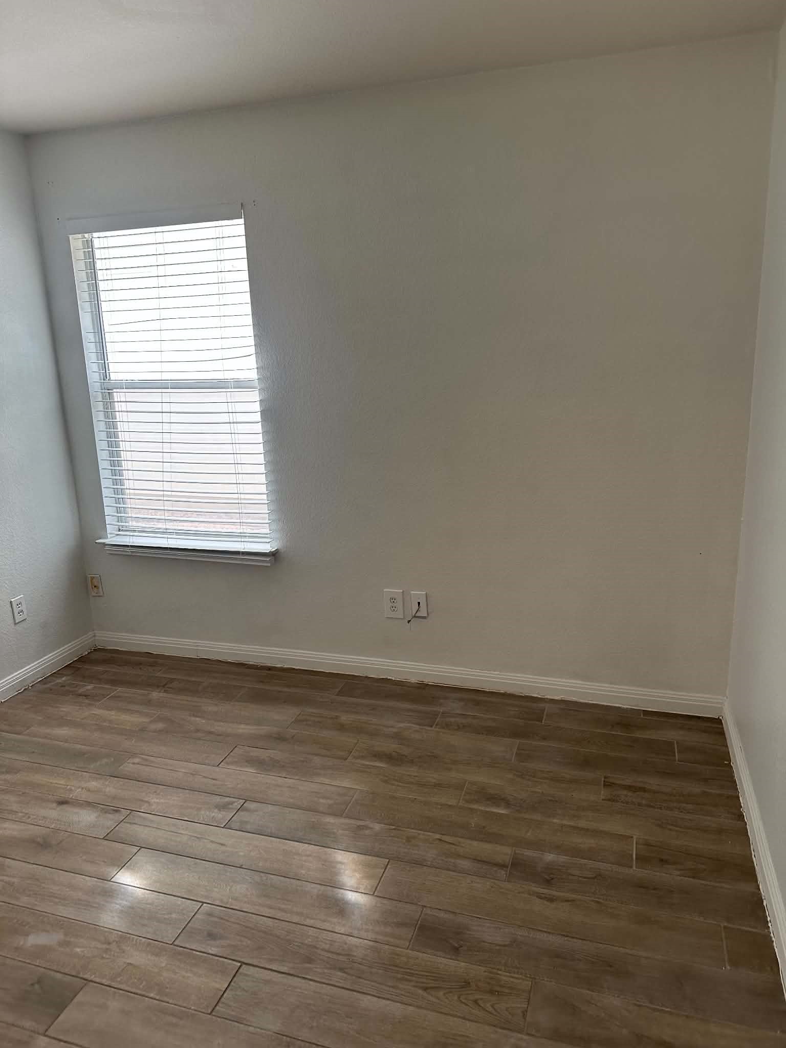 18312 Crestwind Lane Elgin, TX 78621 - Photo 9 of 15 Well-lit room features durable wood-look flooring and a window with privacy blinds.