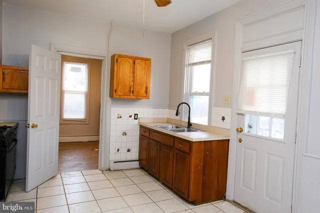 a bathroom with a granite countertop sink a mirror and a shower