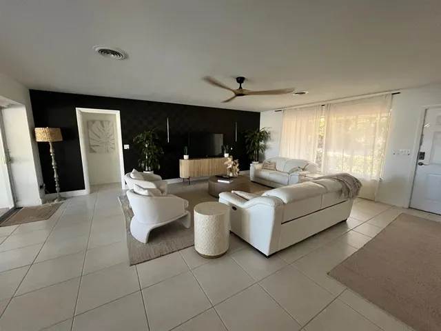 a living room with furniture potted plant and a flat screen tv