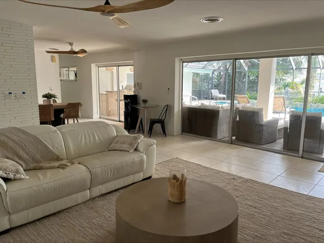 a living room with furniture potted plant and a large window