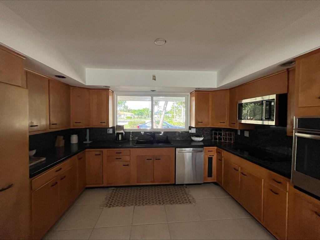 556 Southeast 15th Avenue Deerfield Beach, FL 33441 - Photo 22 of 42 a kitchen with granite countertop a sink and cabinets