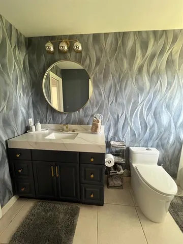 a bedroom with a bed a chair and a large window