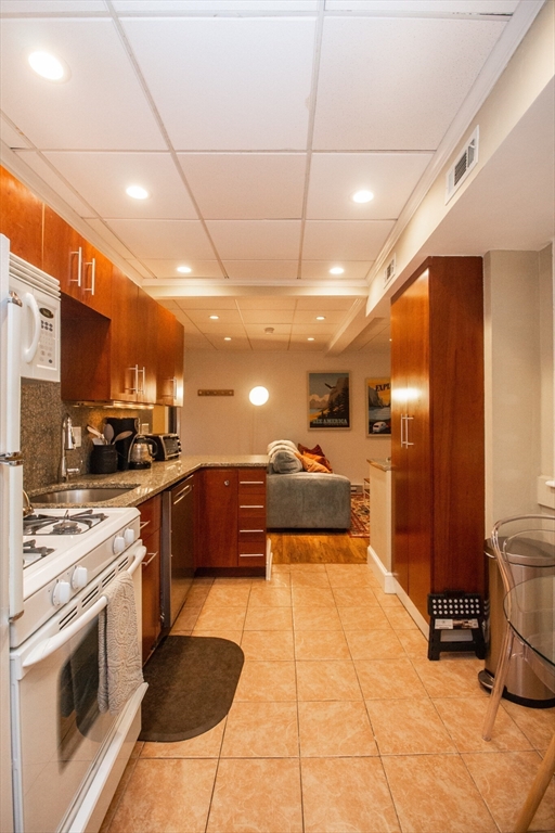 1253 Beacon Street, Unit 4BB Brookline, MA 02446 - Photo 12 of 18 a large kitchen with stainless steel appliances kitchen island granite countertop a large stove a sink a refrigerator and island