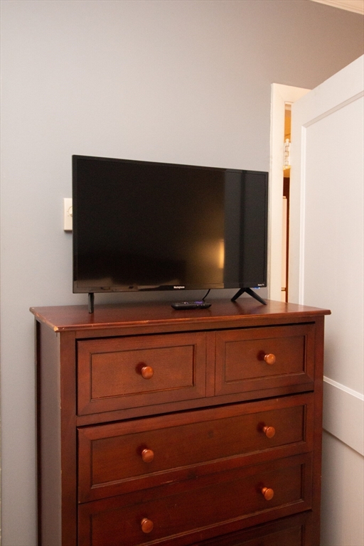 1253 Beacon Street, Unit 4BB Brookline, MA 02446 - Photo 17 of 18 a living room with flat screen tv and dresser
