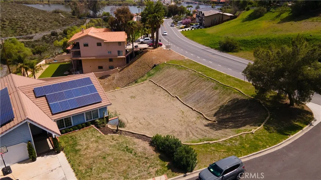 an aerial view of a house with a yard and lake view