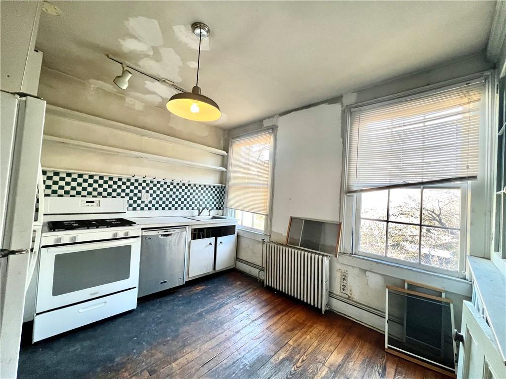 159 Bond Street Brooklyn, NY 11217 - Photo 11 of 20 a kitchen with granite countertop a stove a sink and a window