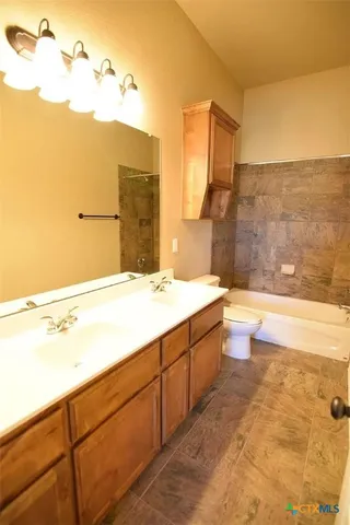 a bathroom with a bathtub sink and mirror