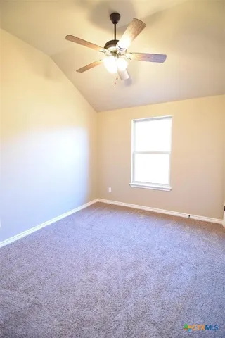 an empty room with a window and a ceiling fan