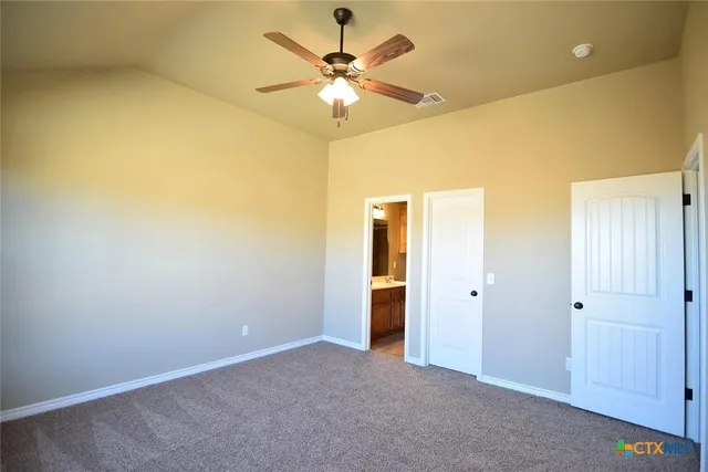 an empty room with closet and a chandelier fan