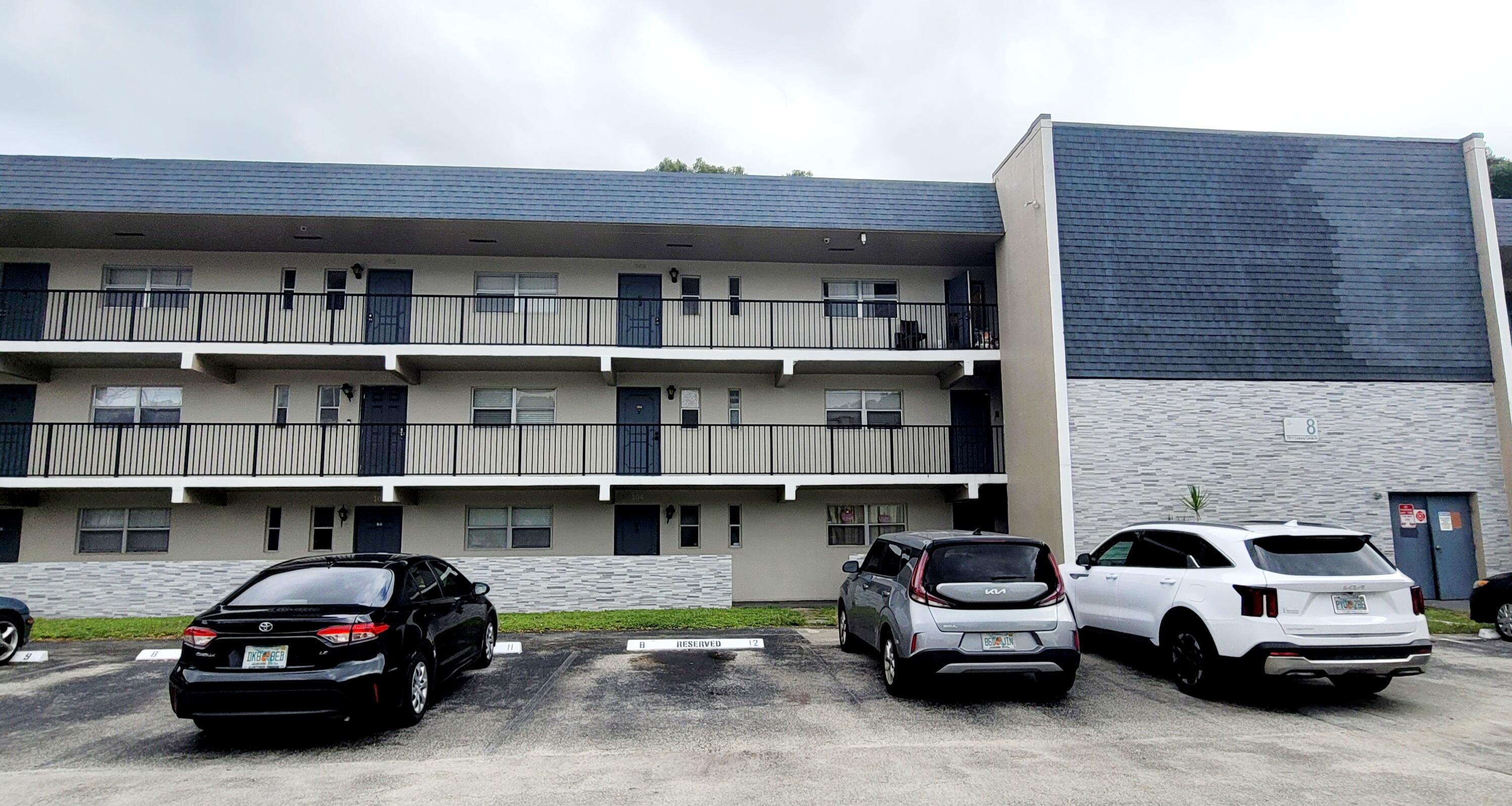 7911 North Colony Circle, Unit 305 Tamarac, FL 33321 - Photo 42 of 42 a car parked in front of a building and cars parked