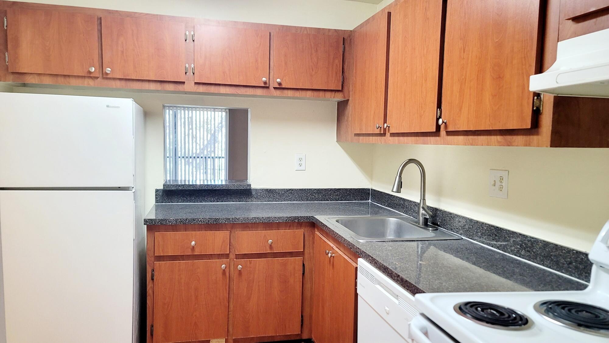 7911 North Colony Circle, Unit 305 Tamarac, FL 33321 - Photo 6 of 42 a kitchen with granite countertop a sink and a cabinets