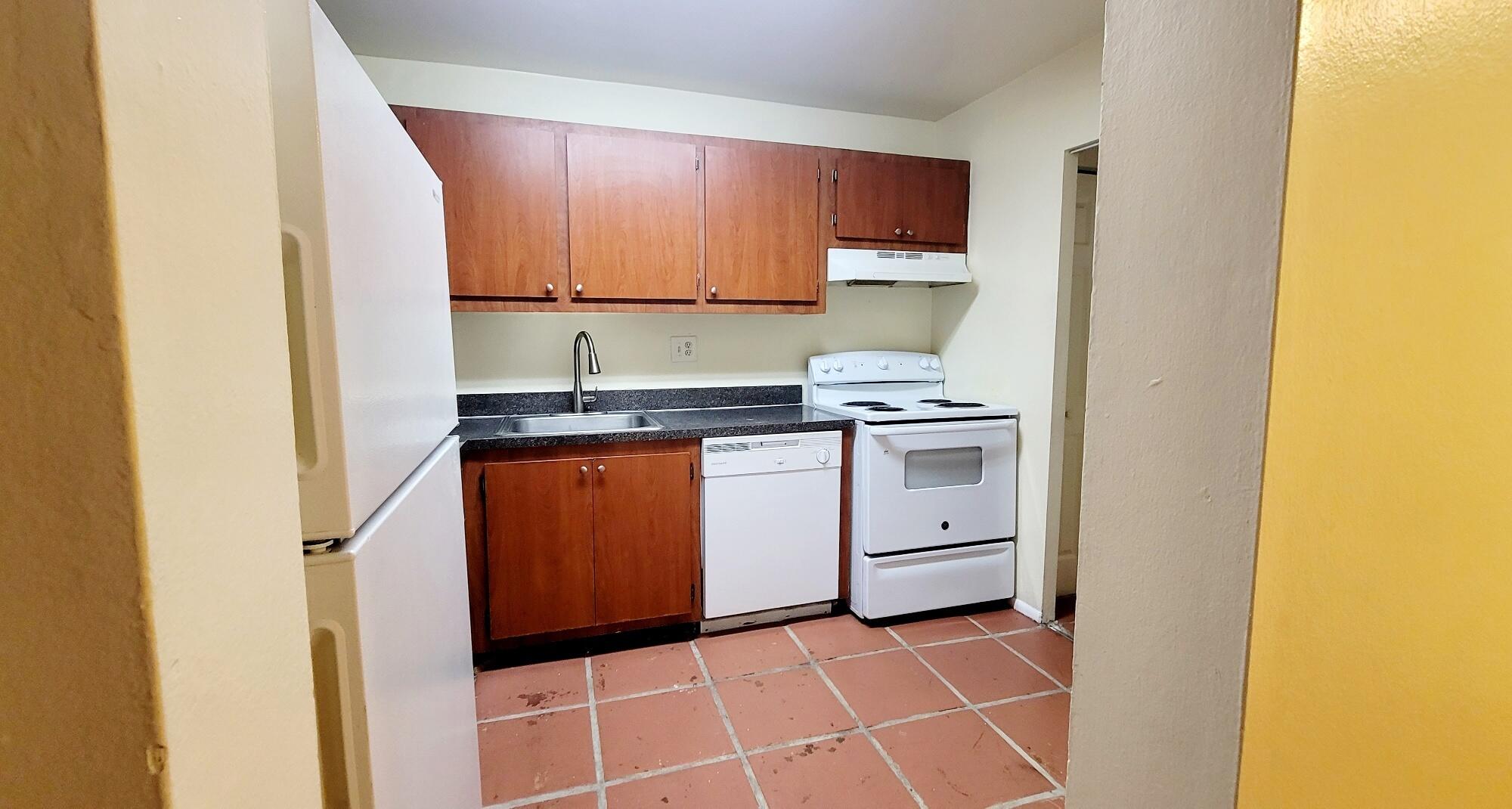 7911 North Colony Circle, Unit 305 Tamarac, FL 33321 - Photo 7 of 42 a kitchen with a stove sink and cabinets