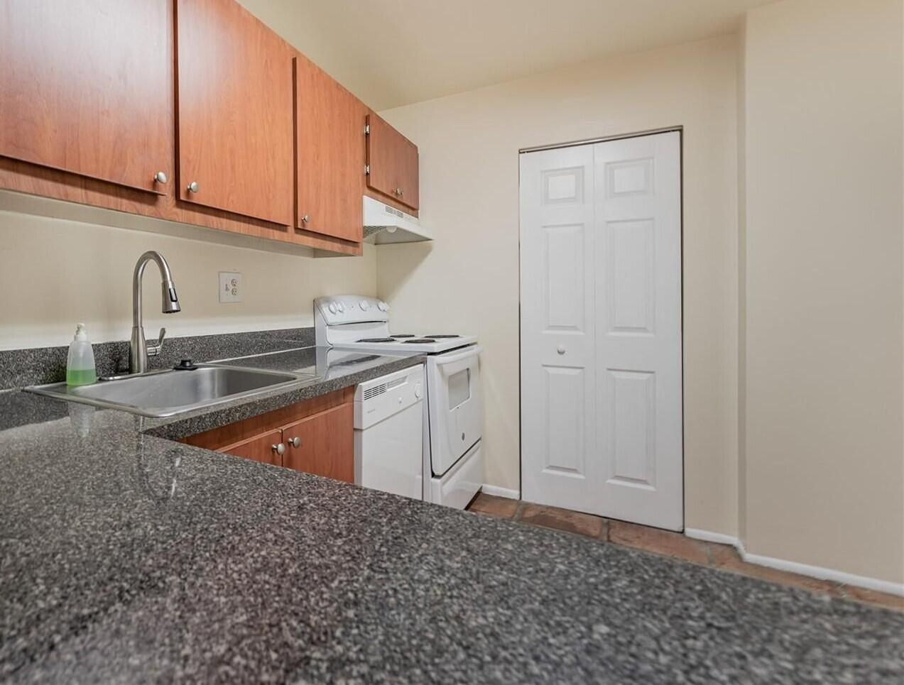7911 North Colony Circle, Unit 305 Tamarac, FL 33321 - Photo 9 of 42 a kitchen with stainless steel appliances granite countertop a sink and a white cabinets